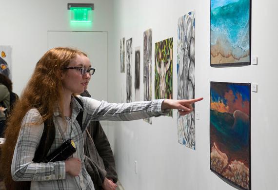 An image of students examining art in a gallery.