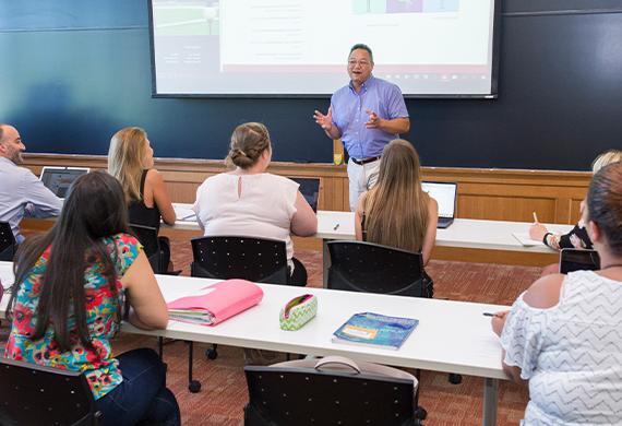 Image of faculty member presenting in a classroom setting.