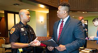 An image of student in conversation with law enforcement officer.